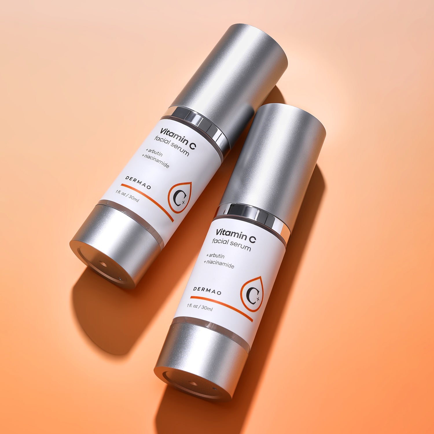 Two bottles of Vitamin C Facial Serum on an orange background